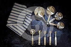 Collection of stainless  measuring cups and measuring spoon with a napkin