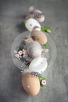 Collection of stylish colors eggs with flowers for Easter celebration on grey background.