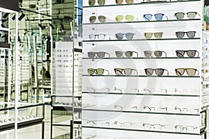 Collection of stylish sunglasses and medical glasses on display in an optical store. Fashion, beauty and health