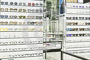 Collection of stylish sunglasses and medical glasses on display in an optical store. Fashion, beauty and health