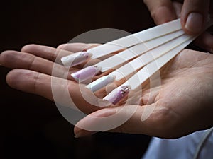 Collection of tips in the hand of the master. The concept of beauty nails.