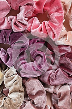 Collection of trendy velvet scrunchies on pink background