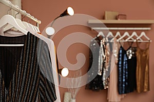 Collection of trendy women`s garments in clothing rental salon, closeup and space for text