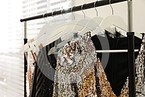 Collection of trendy women`s garments on rack indoors, closeup. Clothing rental service