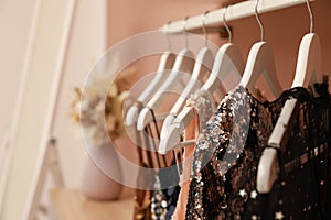 Collection of trendy women`s garments on rack indoors, closeup and space for text. Clothing rental service