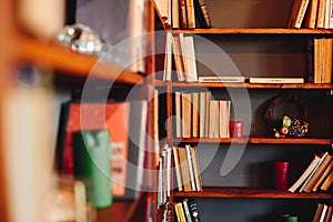 Collection of Various Books on Shelves in Library. Bookcase with Books in Corner. Christmas Candles