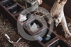 A collection of various different crystals on a messy wiccan witch`s altar