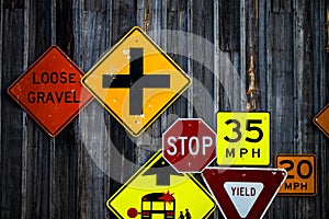 Collection of various road signs on rustic wooden wall