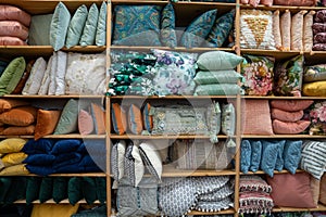 Collection of various throw pillows and decorative pillows on shelf inside storage of store