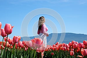 collection of videos and photos where a girl in a white skirt walks through field with tulips blue background sky