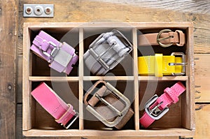 Collection of vintage belts in wooden crate