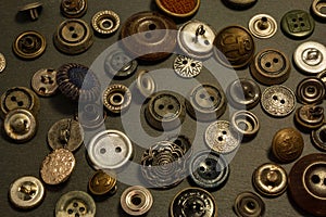 Collection of vintage clothing buttons. Dark stone background, grunge photo.