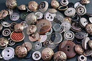 Collection of vintage clothing buttons. Dark stone background, grunge photo.