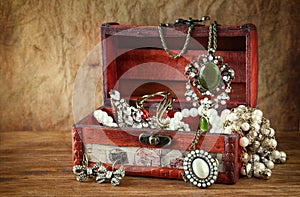 A collection of vintage jewelry in antique wooden jewelry box