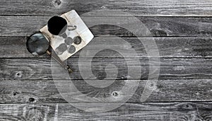 Collection of vintage US silver dollars on faded envelope with magnify glass and a cup of coffee