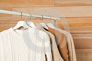 Collection of warm sweaters hanging on rack