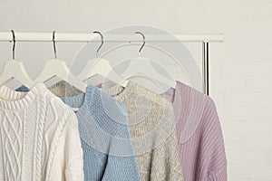 Collection of warm sweaters hanging on rack