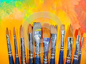 Much used art paint brushes with beautiful abstract background