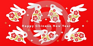 Collection of white bunnies with sakura flowers on a red. Chinese new year 2023 greeting card with lunar zodiac symbol of rabbit