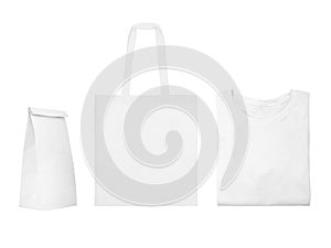 Collection of white objects isolated on white background. White cotton bag, white folded t-shirt, paper bag package