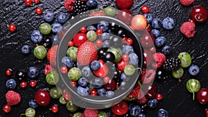 Collection of wild berries on black background, top view