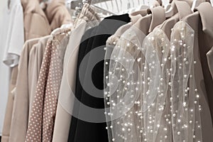 collection of women\'s festive elegant clothes with sequins and rhinestones on hangers in the store. the concept of conscious