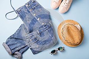 Collection of womens  summer clothes  and accessories  collage on blue. Jeans overall and wicker hat, flat lay,