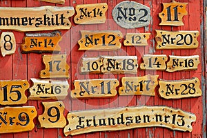 Collection of the wooden house numbers against the red painted wall.