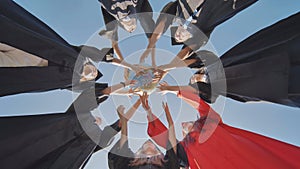 College alumni students toss a globe of the world into the sky.