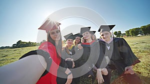 College alumni take selfies in the meadow.