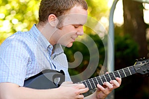 College Boy Concentrating on Guitar