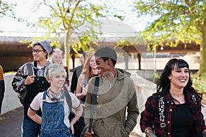 College, campus and group of students walking at university talking and speaking with diversity ready for learning