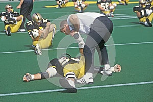 College football player doing pre-game stretch at the Army vs. Lafayette game, Michie Stadium, New York