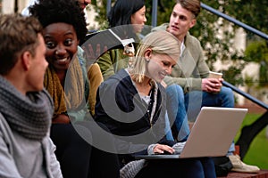 College, friends and laptop on stairs outdoor for research, relax or break on campus with social media. University