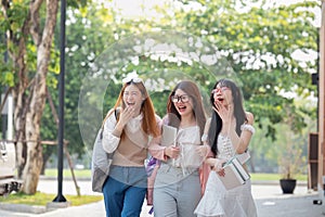 College friends walk to class together. University student in campus talk and have fun outdoors