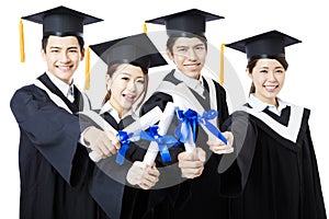 College graduates in graduation gowns standing and smiling