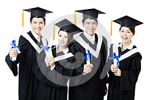 College graduates in graduation gowns standing and smiling