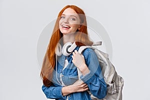 College life, modern lifestyle and education concept. Cheerful good-looking redhead female student with foxy long hair