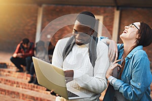 College - lots of learning and lots of fun. Shot of a young man and woman using a laptop together on campus.