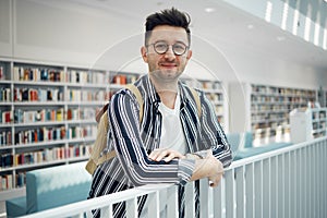 College, portrait and man student in a bookstore for studying, learning or knowledge with books. Education, library and