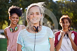 College, portrait and students in the park with headphones on campus to study together with happiness and friends