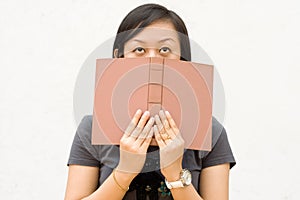 College student covering her face with book