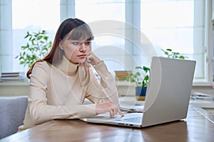 College student girl sitting at desk using computer, typing on a keyboard