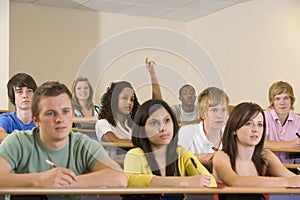 College student with hand raised in lecture