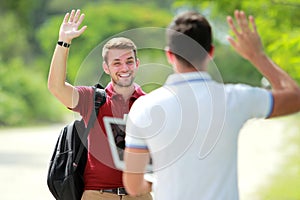 College student meet his friend and waving his hand