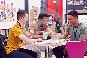 College Student Meeting With Male Tutor In Busy Communal Campus Building