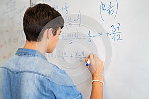 College student solving math equation on white board