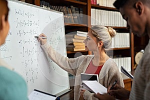 College student solving math on whiteboard