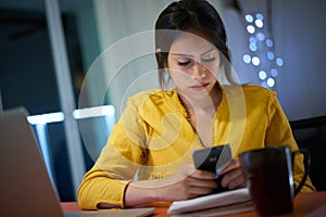 College Student Studying At Night Types Message On Phone