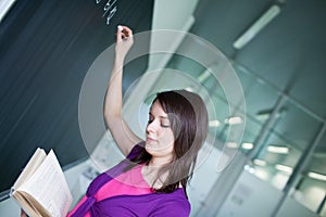 College student writing on the chalkboard